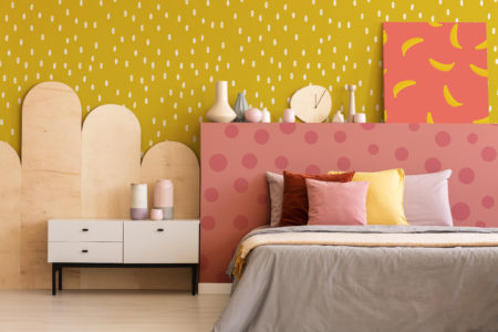 Colorful painting on grey bedhead of bed with cushions in bedroom interior with kavinet. Real photo